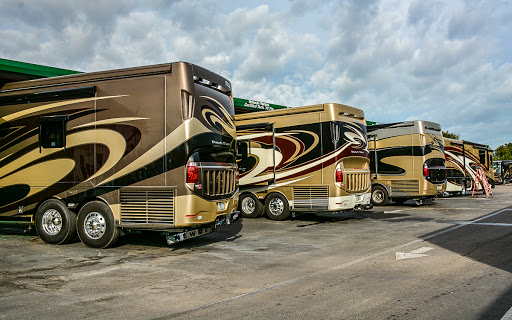 A group of RVs parked side by side in a lot.